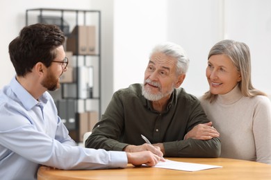 Notary consulting senior couple about Last Will and Testament in office