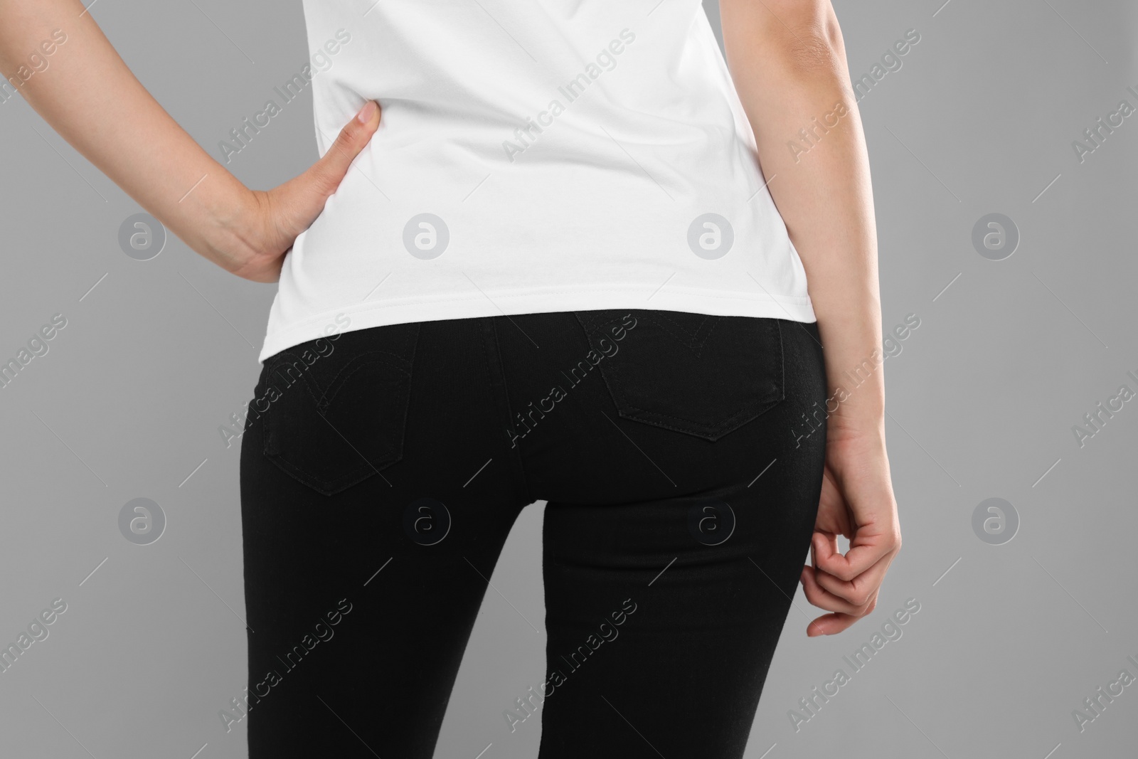 Photo of Woman wearing stylish black jeans on light gray background, closeup