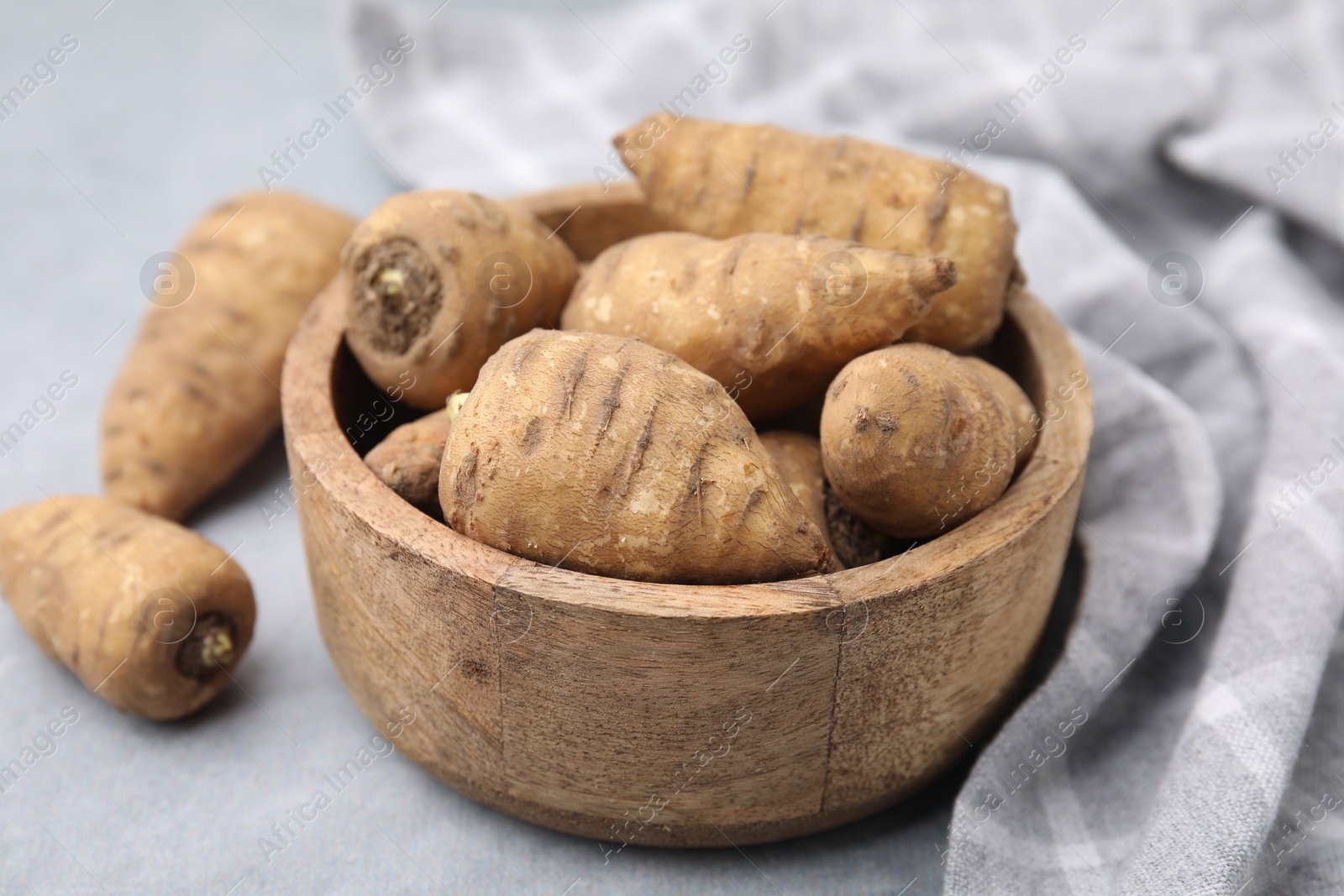 Photo of Tubers of turnip rooted chervil on light grey table, closeup