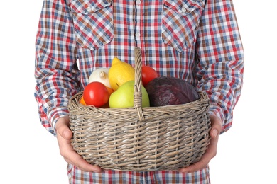 Photo of Man holding basket full of fresh  vegetables and fruits against white background, closeup