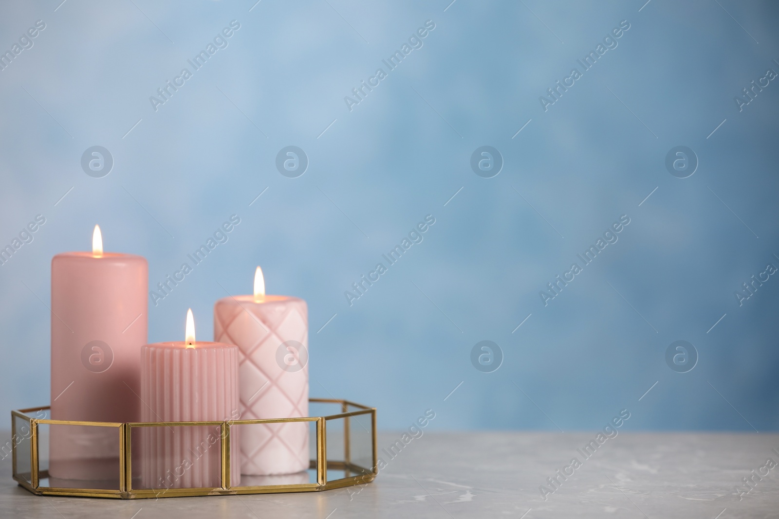 Photo of Burning candles on light grey marble table. space for text