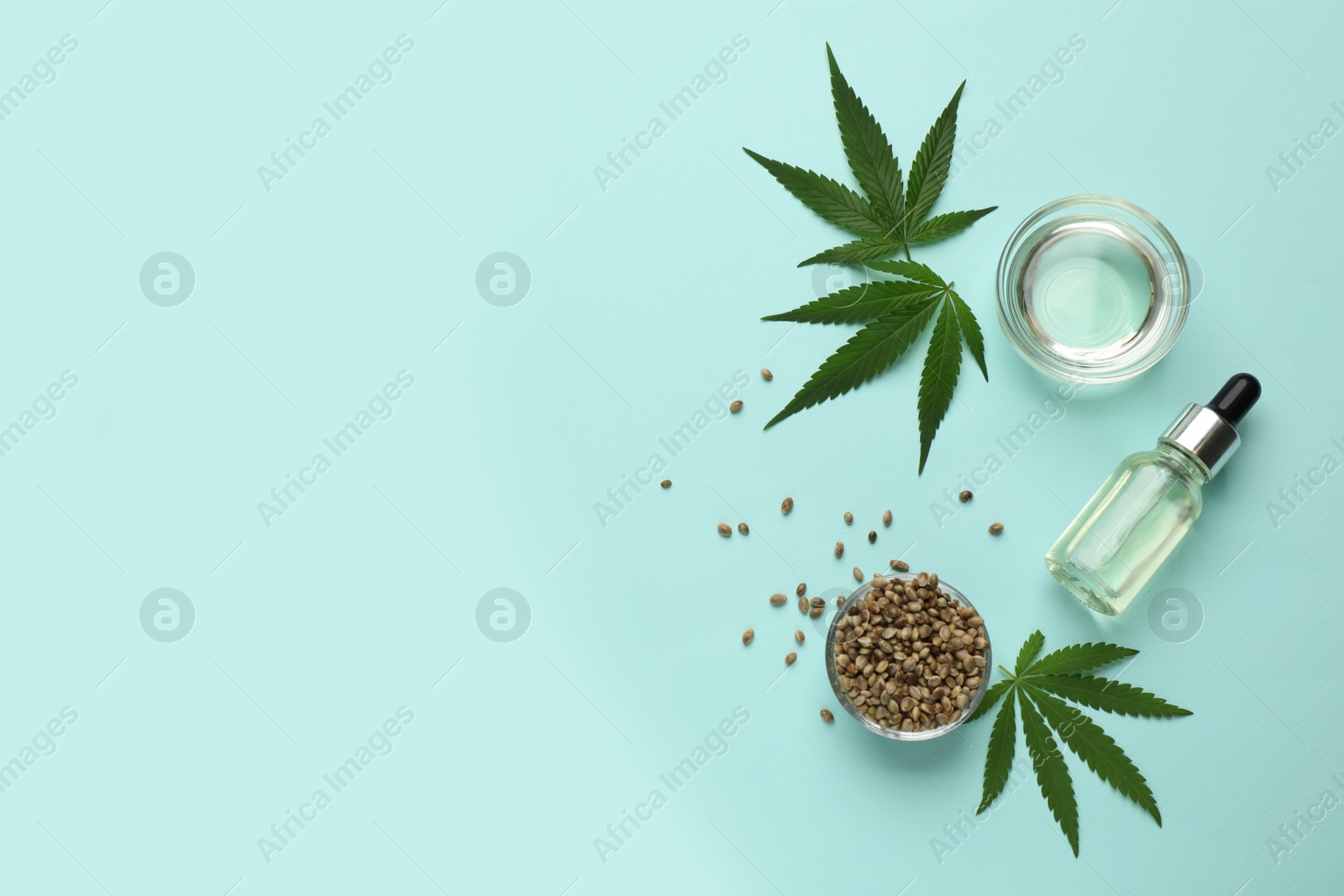 Photo of Flat lay composition with CBD oil or THC tincture and hemp leaves on light blue background, space for text