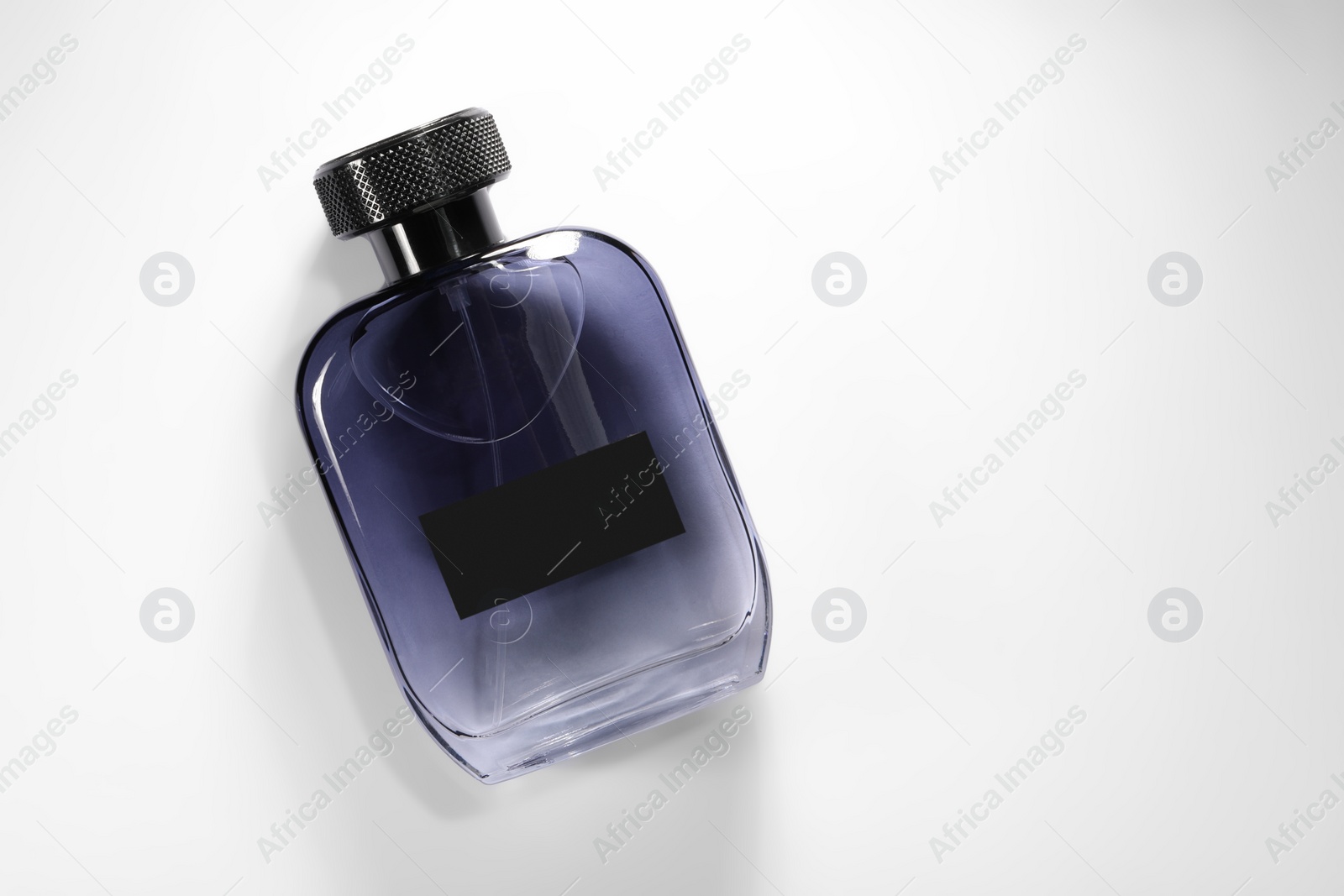 Photo of Luxury men`s perfume in bottle on white background, top view. Space for text