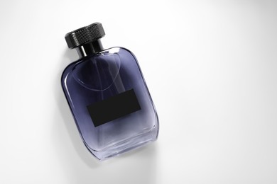 Luxury men`s perfume in bottle on white background, top view. Space for text