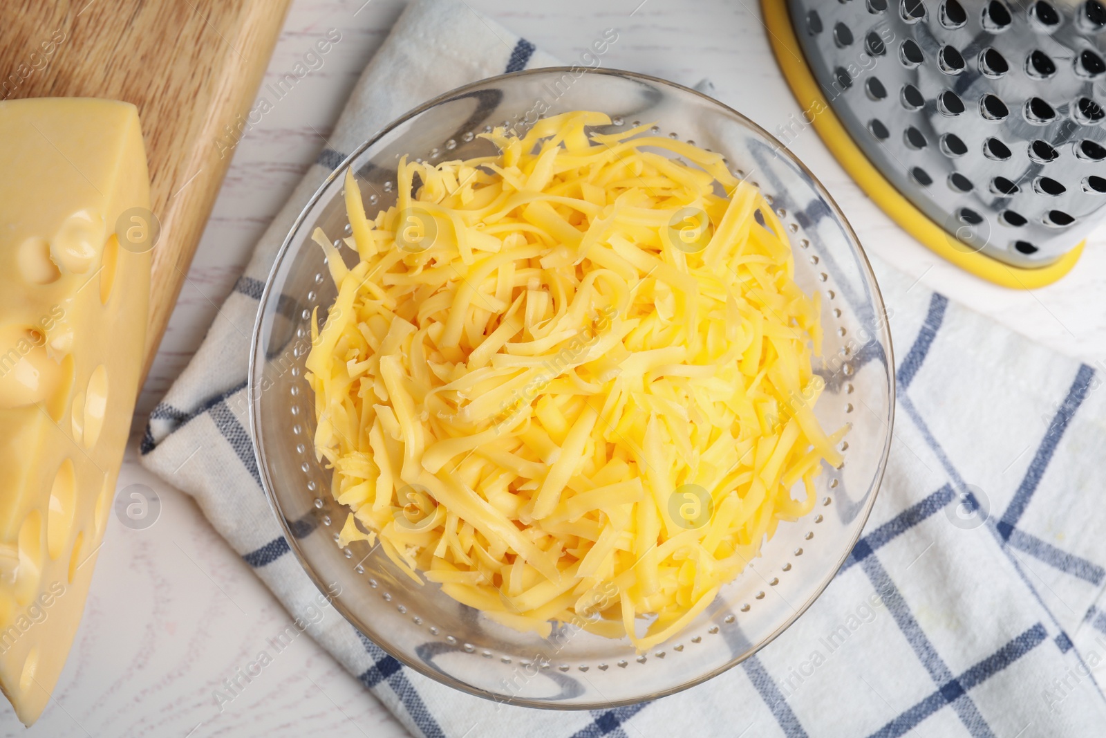 Photo of Tasty grated cheese on white wooden table, flat lay