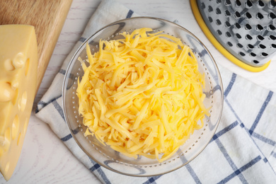 Tasty grated cheese on white wooden table, flat lay