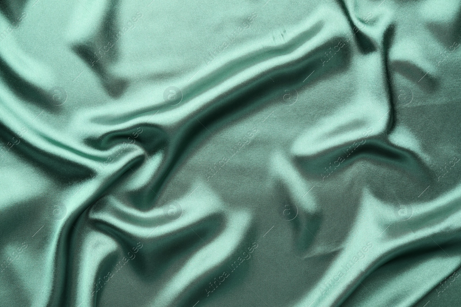 Photo of Crumpled green silk fabric as background, top view