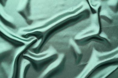 Crumpled green silk fabric as background, top view