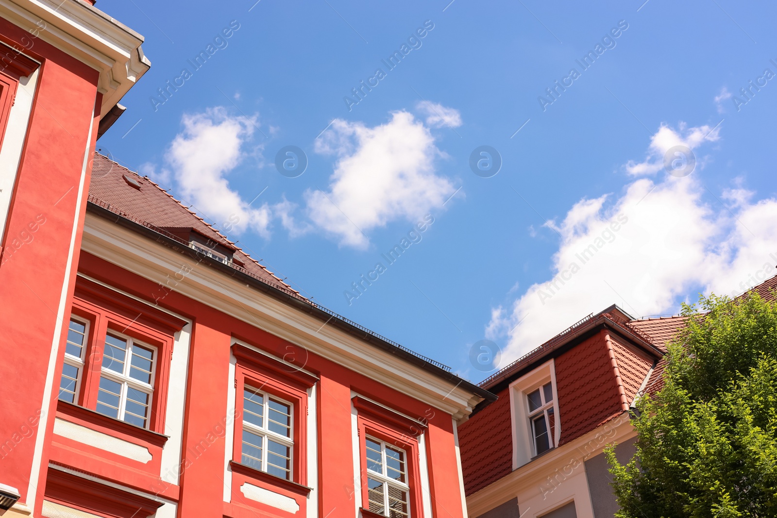 Photo of Beautiful building and green tree against cloudy sky, low angle view