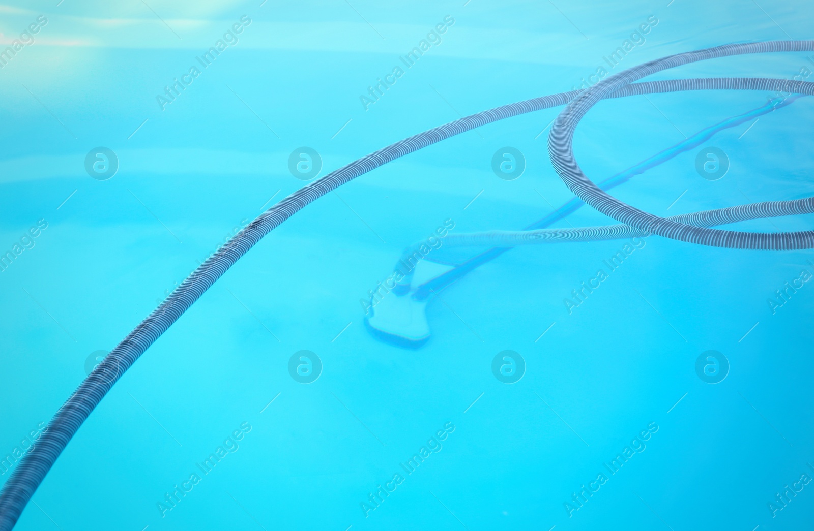 Photo of Cleaning outdoor swimming pool with underwater vacuum