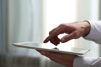 Closeup view of man using new tablet indoors