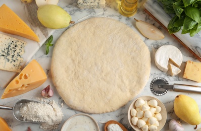 Photo of Flat lay composition with pizza crust and fresh ingredients on marble table