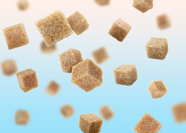 Image of Brown cane sugar cubes falling on light blue gradient background