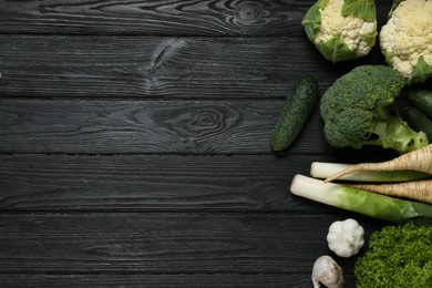 Photo of Different fresh ripe vegetables on black wooden table, flat lay with space for text. Farmer produce