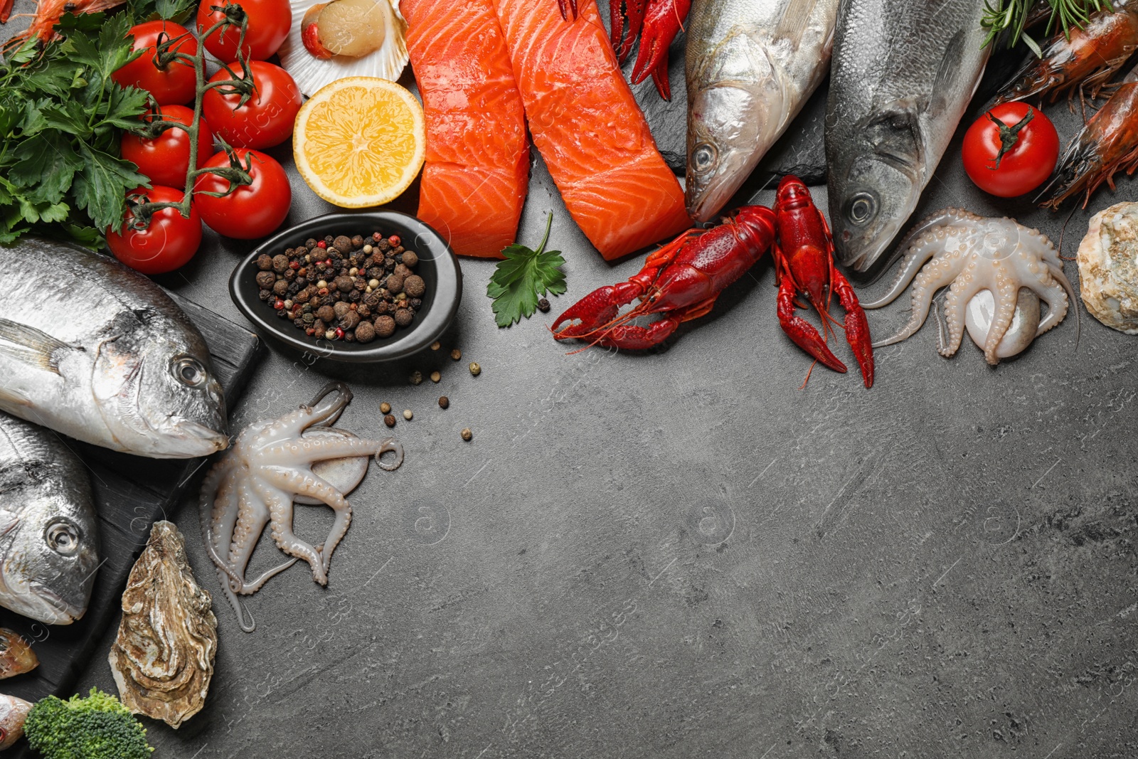 Photo of Fresh fish and different seafood on grey table, flat lay. Space for text