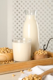 Fresh soy milk and beans on wooden table, closeup