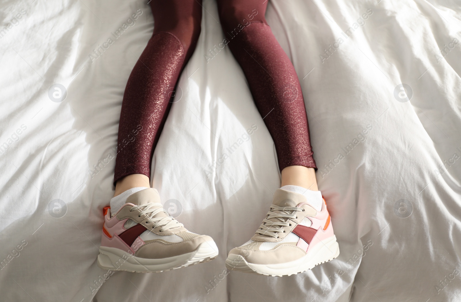 Photo of Lazy young woman sleeping on bed instead of morning training, top view