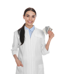 Professional pharmacist with pills on white background