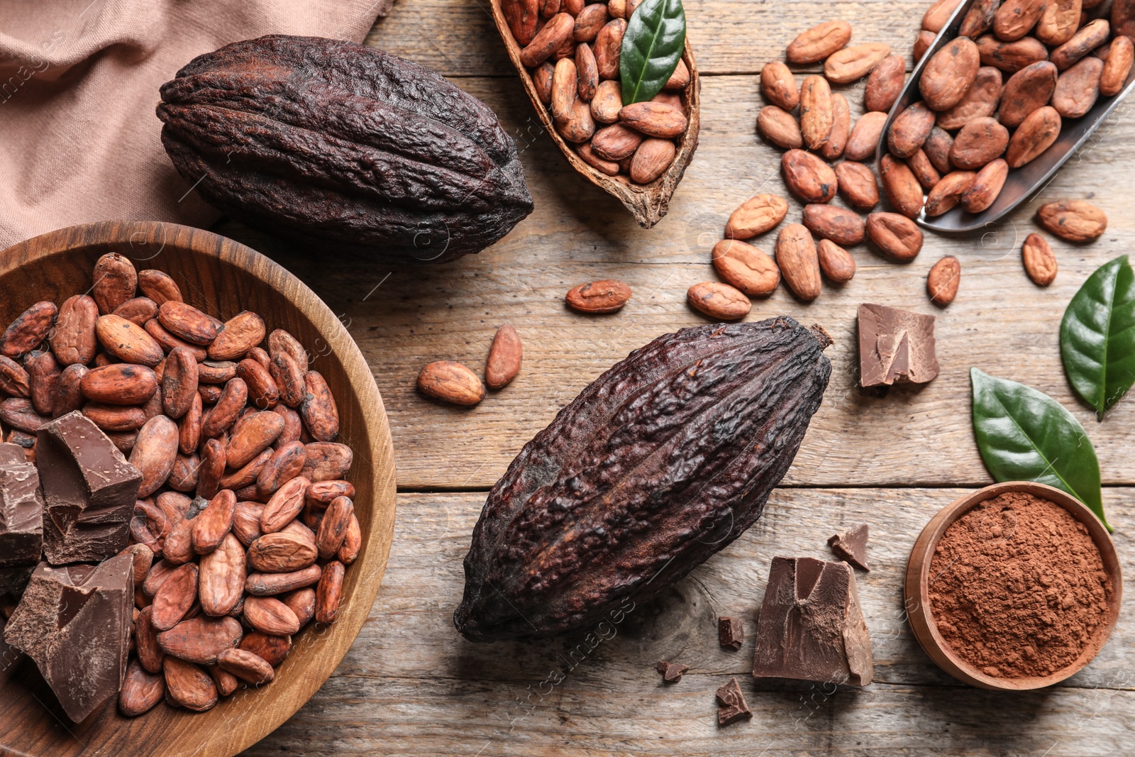 Photo of Flat lay composition with cocoa beans, chocolate pieces and pods on wooden table