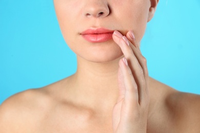 Closeup view of beautiful young woman on color background. Lips contouring, skin care and cosmetic surgery concept