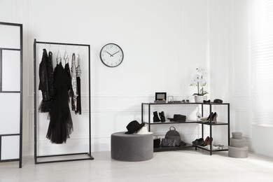 Photo of Stylish dressing room interior with trendy clothes, shoes and accessories