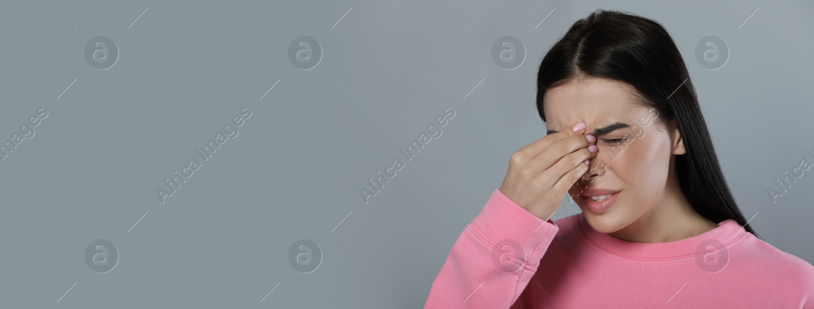 Image of Woman suffering from migraine on grey background, space for text. Banner design