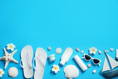 Flat lay composition with stylish beach accessories on light blue background, space for text