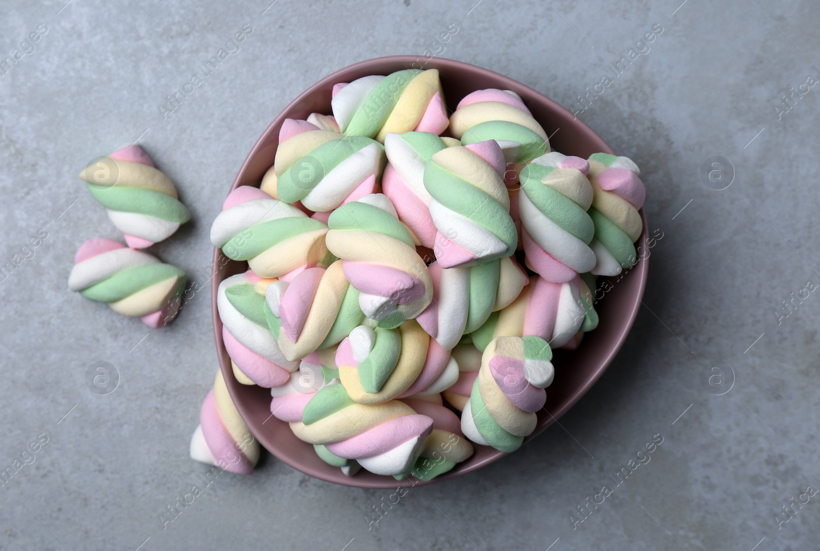 Photo of Bowl with colorful marshmallows on grey table, flat lay