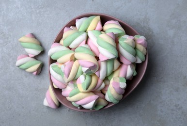 Photo of Bowl with colorful marshmallows on grey table, flat lay