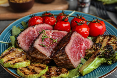 Photo of Delicious sliced beef steak with vegetables, closeup view