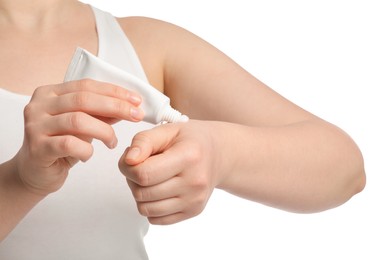 Photo of Woman applying ointment from tube onto her hand on white background, closeup