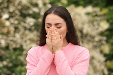 Woman suffering from seasonal spring allergy outdoors