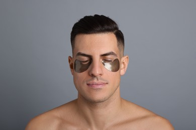 Photo of Man with dark under eye patches on grey  background