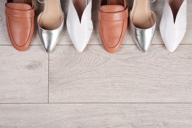 Photo of Different female shoes on wooden background, top view