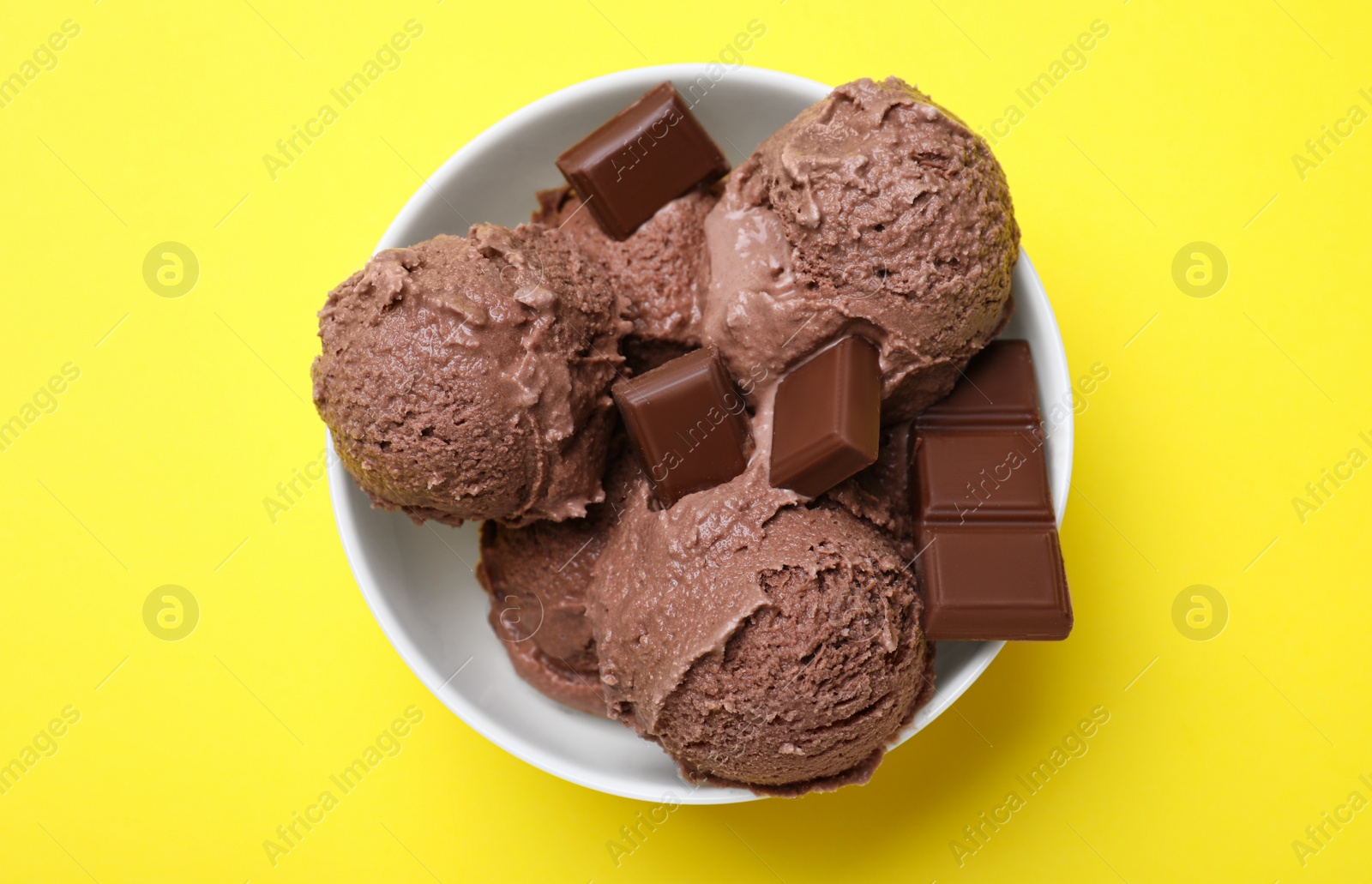 Photo of Delicious chocolate ice cream on yellow background, top view