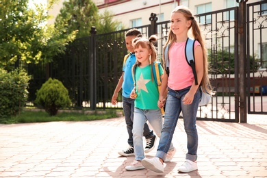 Cute little children with backpacks going to school