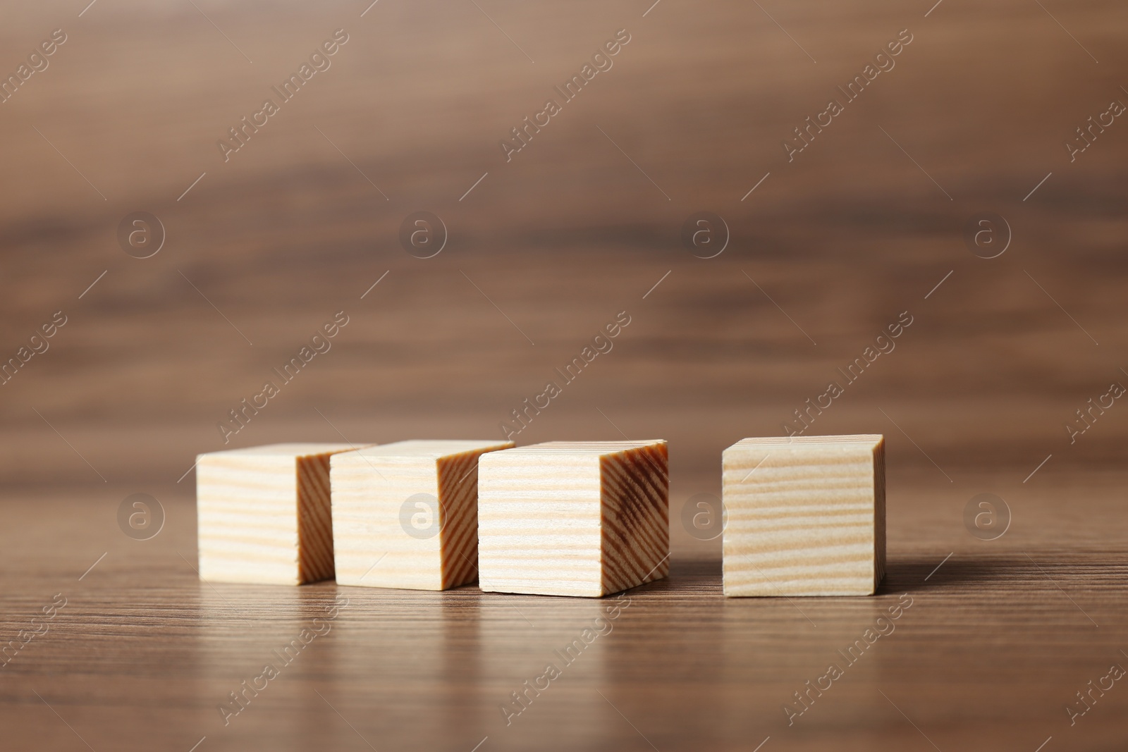 Photo of Cubes in row on wooden background. Idea concept