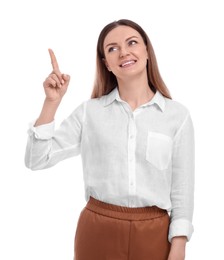 Beautiful happy businesswoman pointing at something on white background