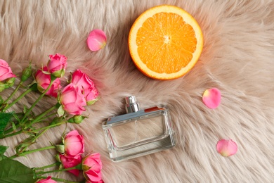 Beautiful composition with bottle of perfume on fur, flat lay