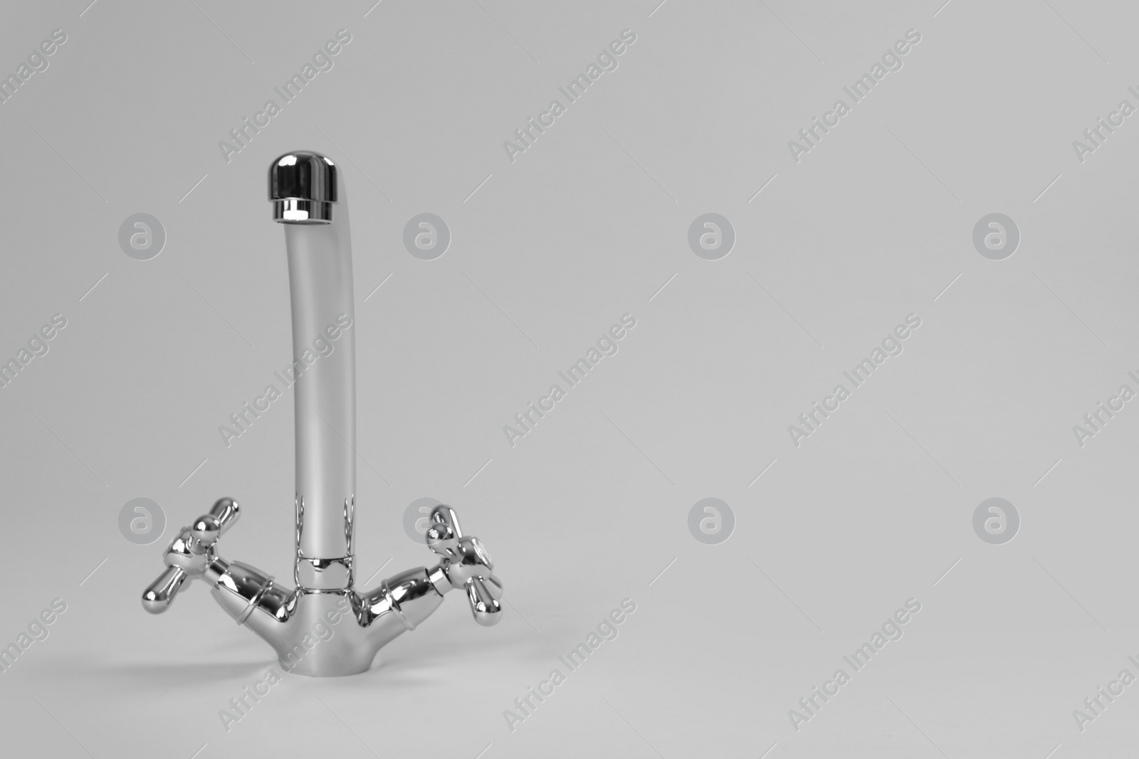 Photo of Double handle water tap on grey background. Space for text