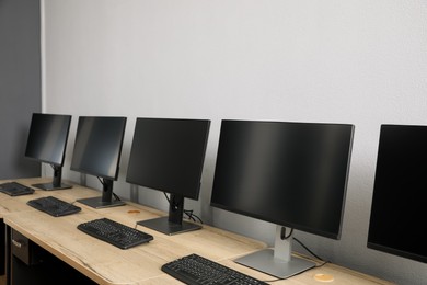 Open office interior. Modern workplaces with computers near light grey wall