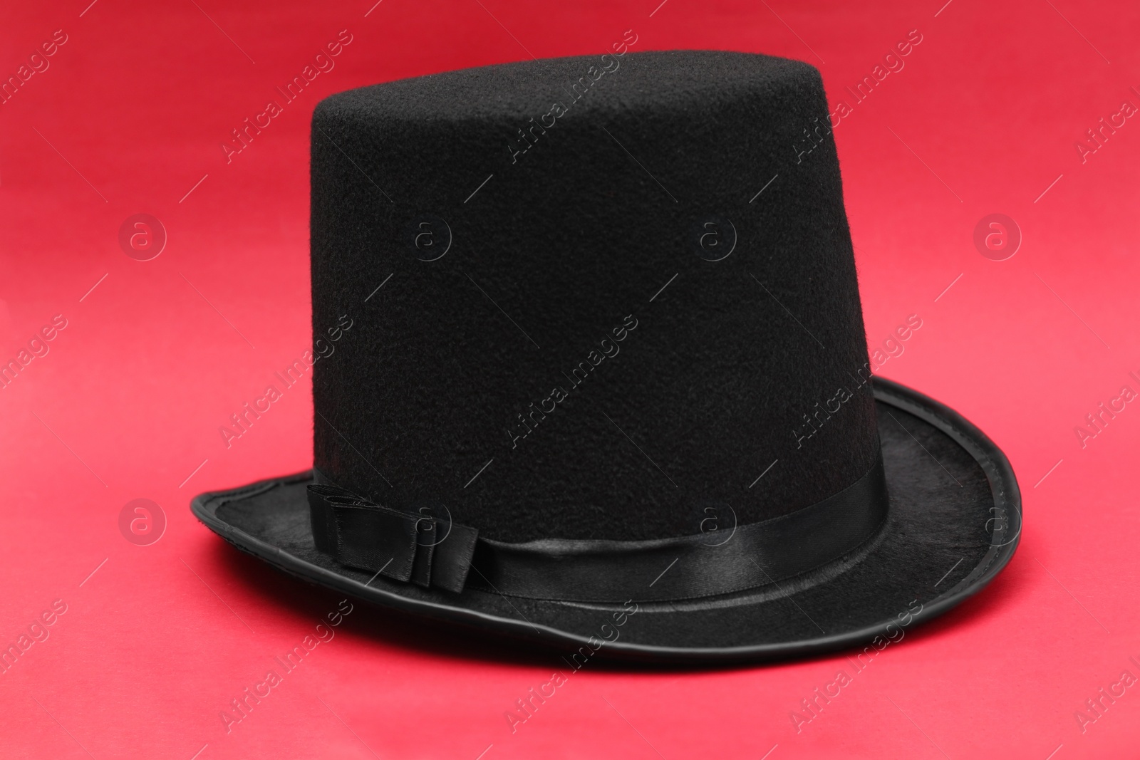 Photo of One magician top hat on red background