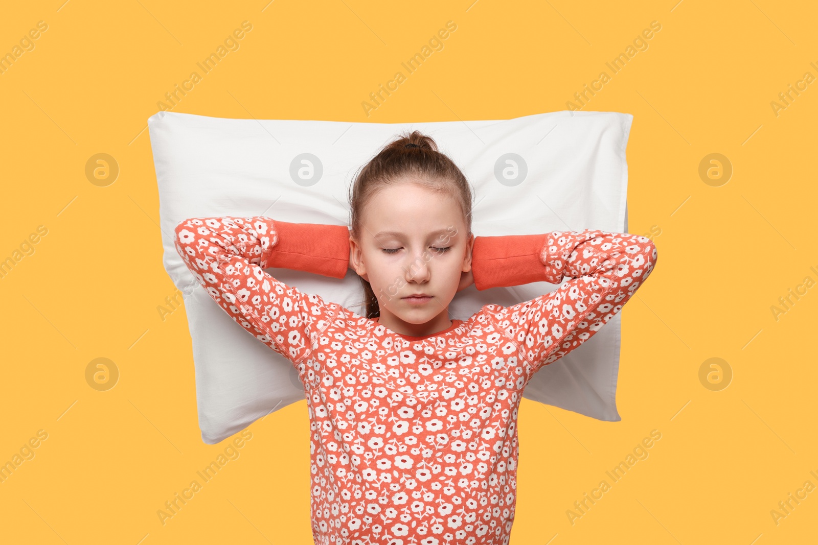 Photo of Sleepy girl with pillow on orange background. Insomnia problem