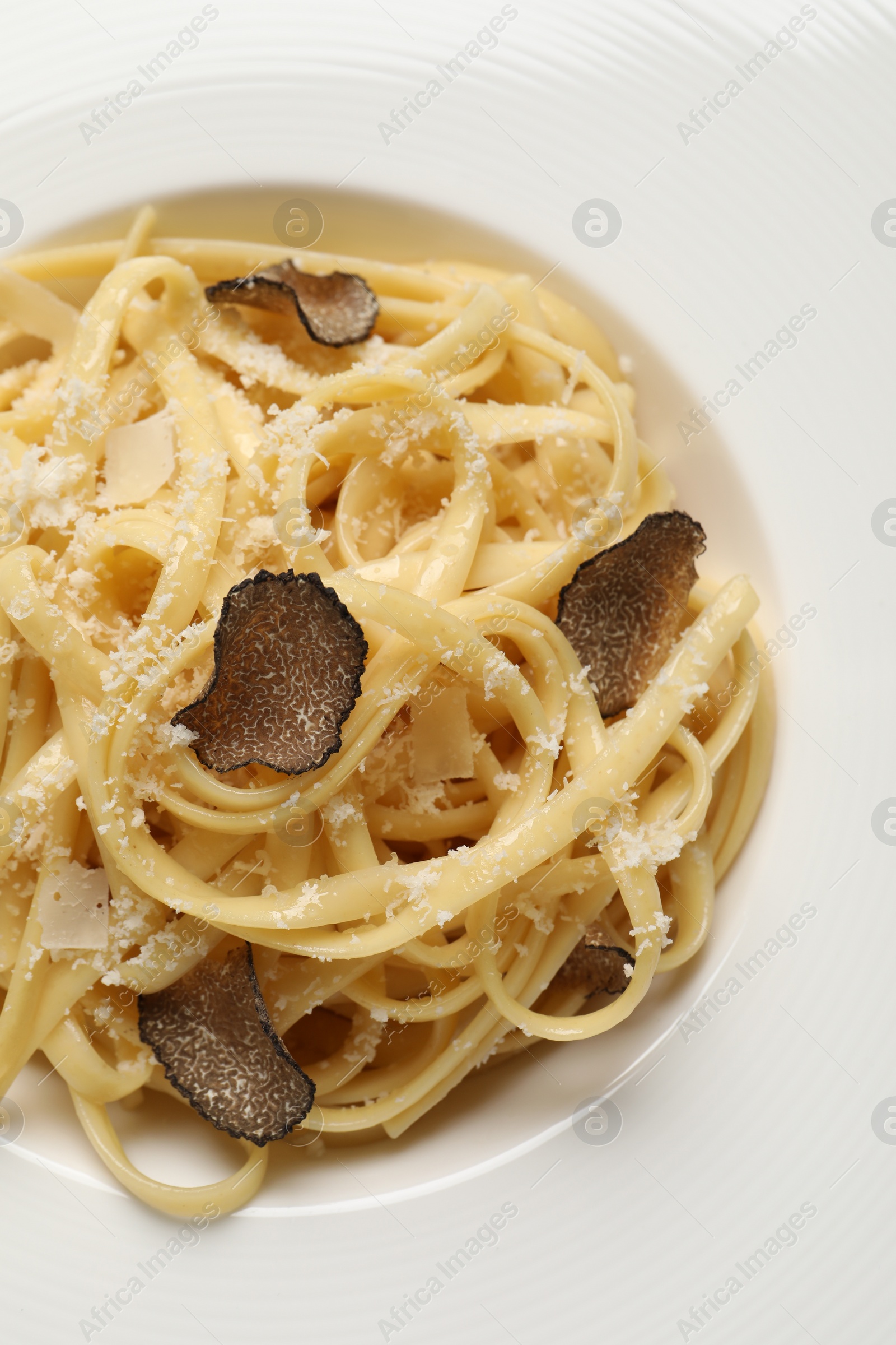 Photo of Delicious pasta with truffle slices and cheese on plate, closeup