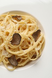 Delicious pasta with truffle slices and cheese on plate, closeup