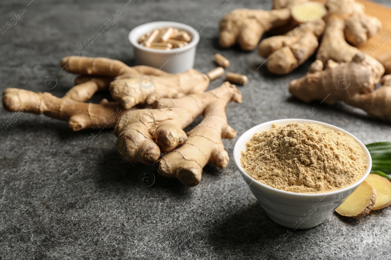 Photo of Dry, fresh and capsuled ginger on grey table. Space for text