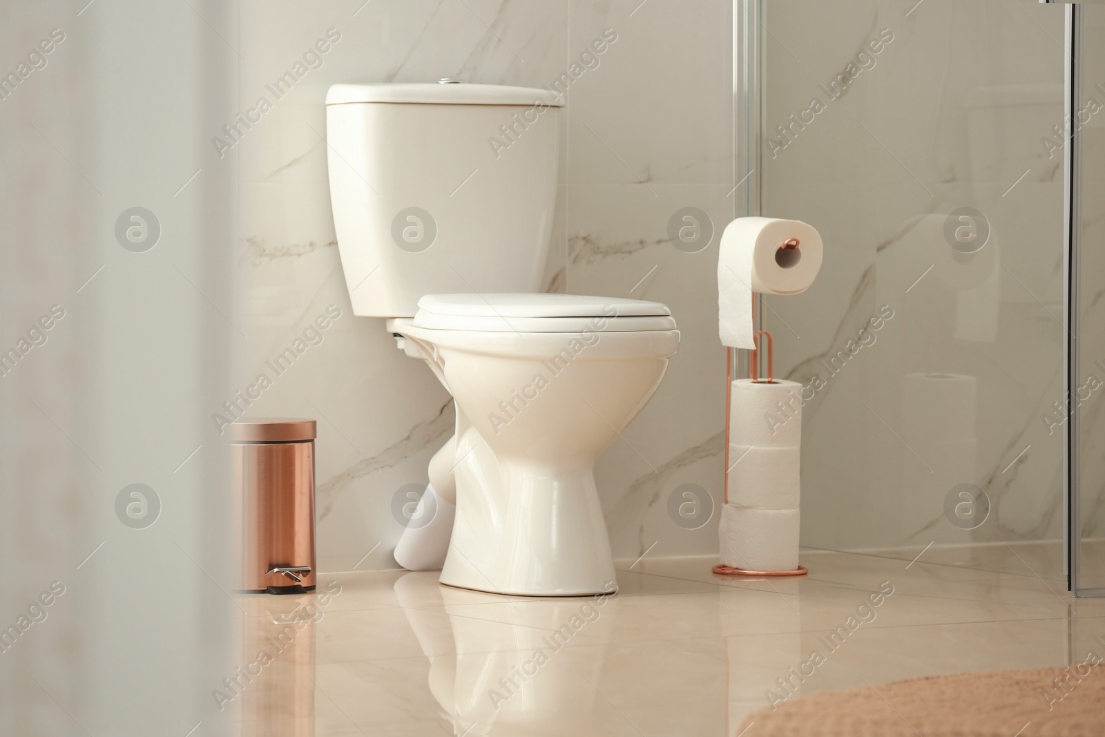 Photo of Modern toilet bowl with roll of paper in bathroom