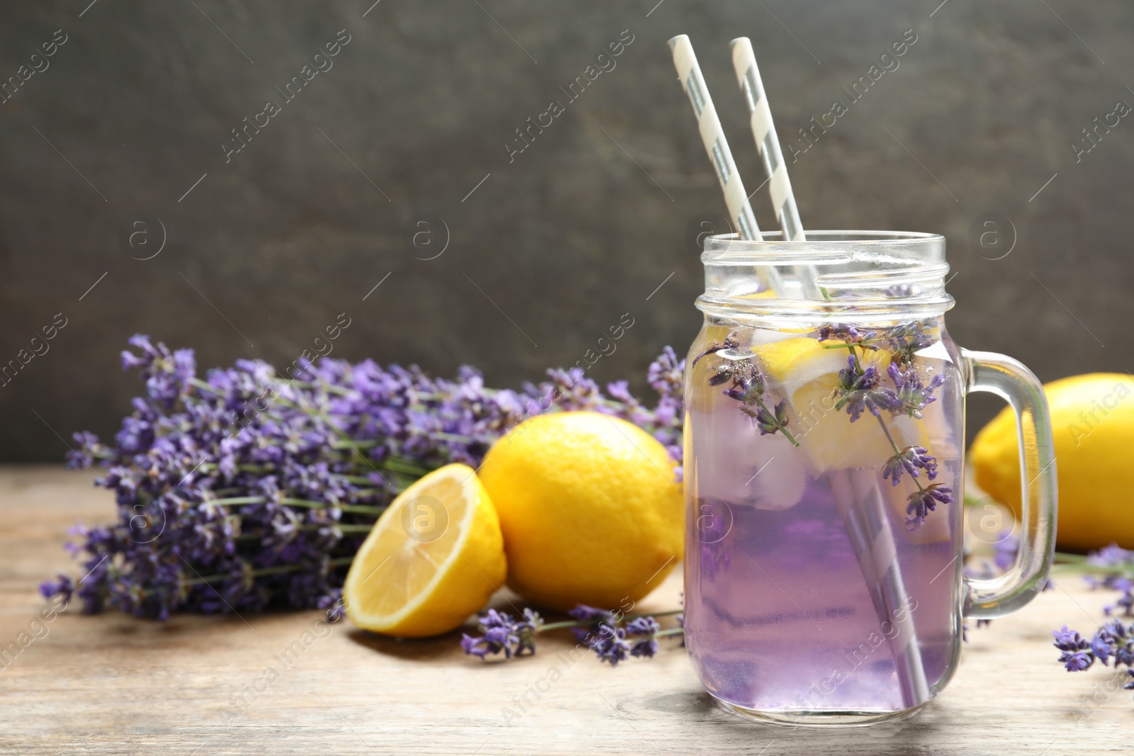 Photo of Fresh delicious lemonade with lavender in masson jar on wooden table