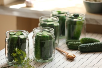 Glass jars with fresh cucumbers and other ingredients on table. Canning vegetables
