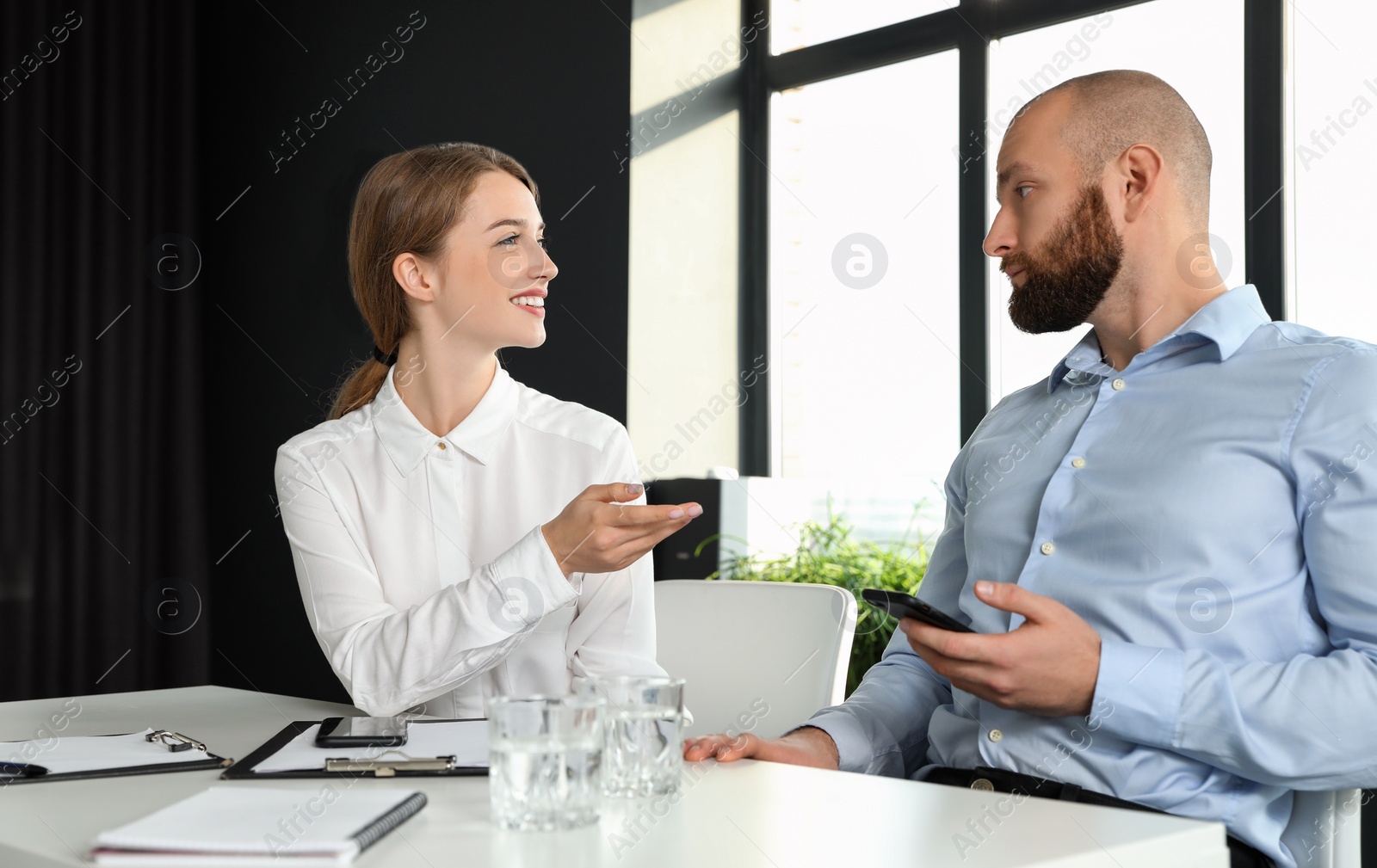 Photo of Business people talking at white table in conference room